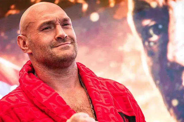 Tyson Fury en peignoir rouge souriant lors d’un événement de presse